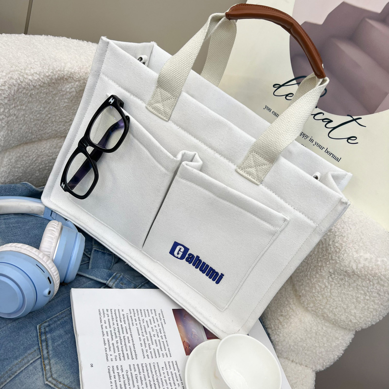 White canvas bag with bottom and side straps and 2 pockets